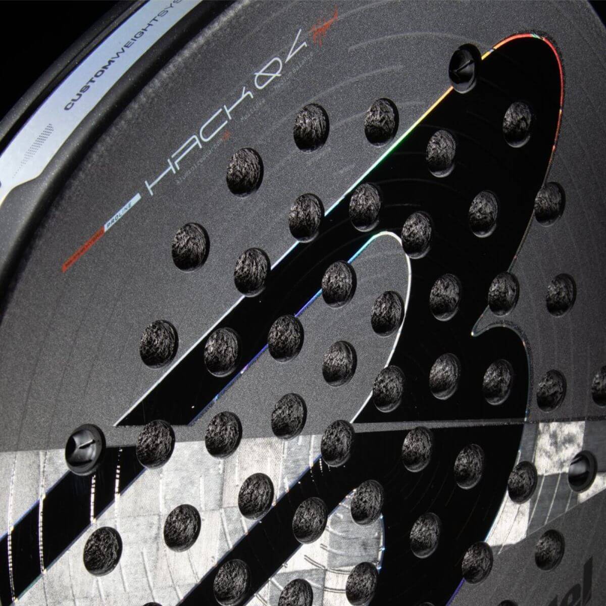 Detail Bullpadel Hack 04 26 padelracket – hybride vorm met 18K Aluminized Carbon, Multieva-kern en 3D Grain voor power en controle in counterattacks.
