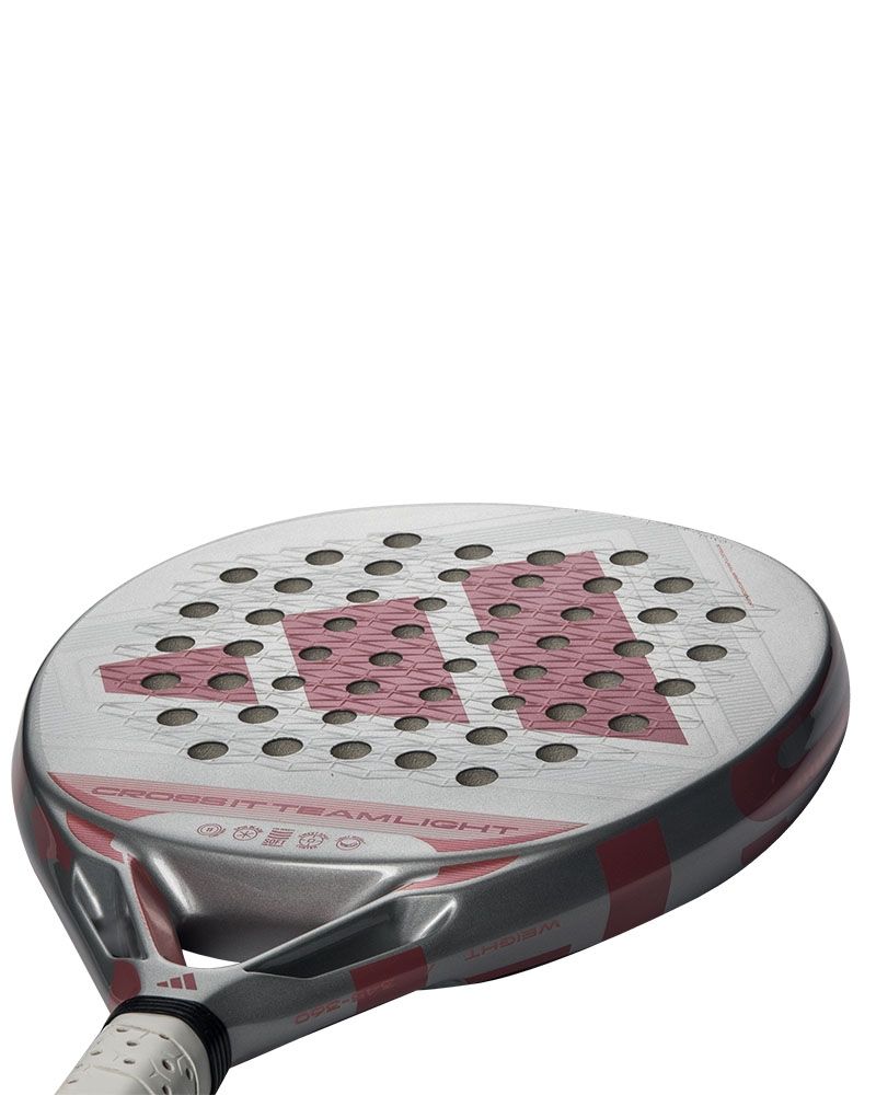 Schuin onderaanzicht Adidas Cross It Team Light 2026: lichtgrijs padelracket (345–360 g) met ronde vorm en roze Adidas logo.