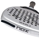 Bovenaanzicht afneembare gewichten Nox Attack 12k 2027 licht grijs padel racket met donkerder grijze x op het slagoppervlak.