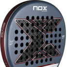 Grijs NOX AT10 Genius 12K 2025 padelracket met zwart X-logo van NOX, vooraanzicht met druppelvormig ontwerp en hoogwaardige afwerking