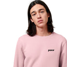 Man met roze sweater met zwart logo pace op de borst