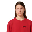 Man met rode sweater met zwart logo pace op de borst